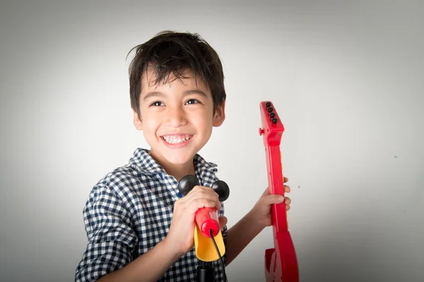 Kleine jongen spelen gitaar en zingen met microfoon — Stockfoto