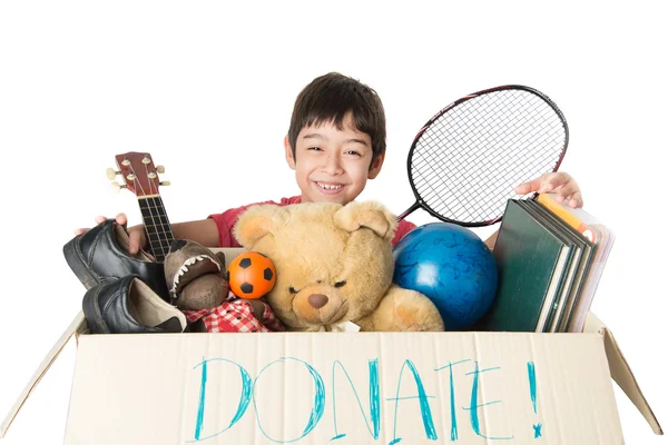 Niño pequeño tomando caja de donación llena de cosas para donar — Foto de Stock