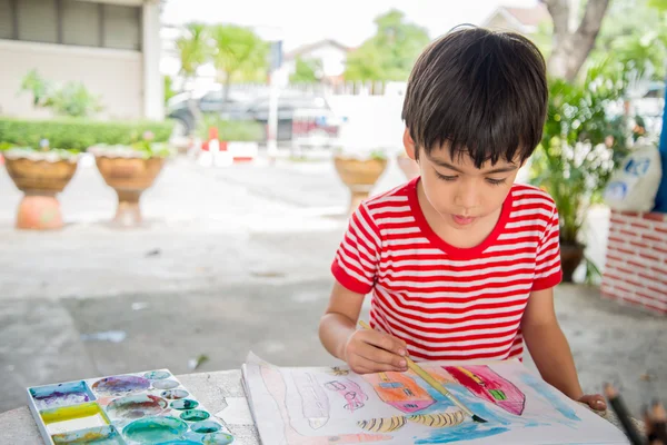 Niño pequeño dibujo de imagen en la mesa al aire libre — Foto de Stock