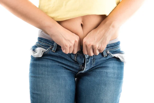 Mujer tratando de cerrar jeans botón con difícil de grasa Fotos De Stock