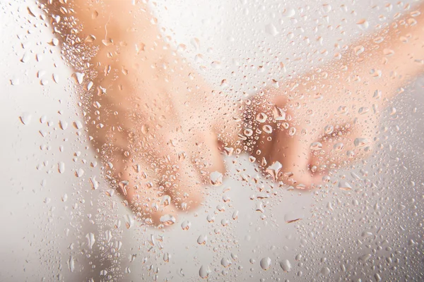 유리에는 물방울 뒤에 아이 들 손을 잡고 엄마 손 — 스톡 사진