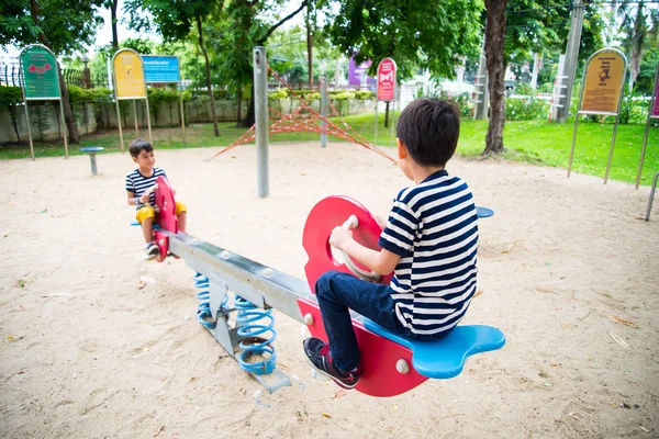 Piccoli ragazzi che giocano altalena insieme nel parco — Foto Stock
