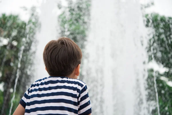 公園内の噴水を見て少年 — ストック写真