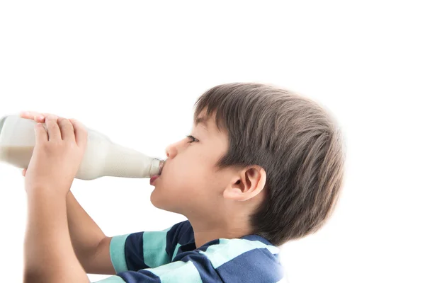 Petit garçon buvant du lait de bouteille sur fond blanc — Photo