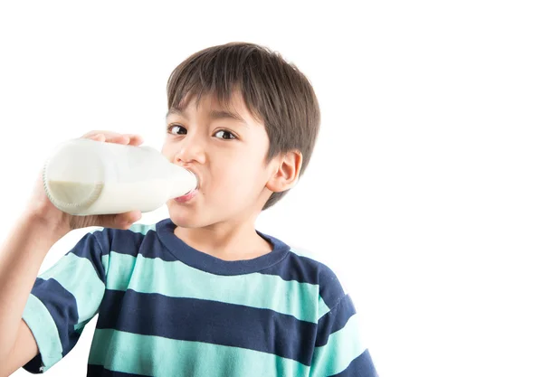 Мальчик пьет молоко из бутылки на белом фоне — стоковое фото