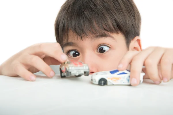 Pieni poika leikkii auton lelua pöydällä — kuvapankkivalokuva