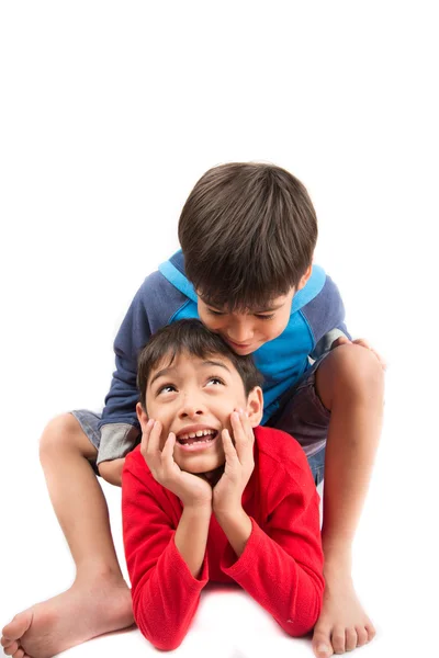 Kleine broer/zus jongens zitten samen op witte achtergrond Rechtenvrije Stockfoto's