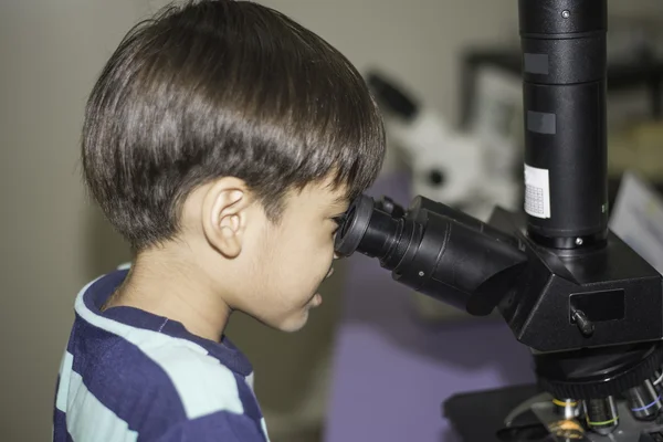 Kleine jongen leren wetenschap klasse met Microscoop — Stockfoto