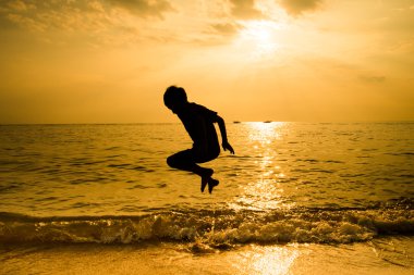 Plaj dalga atlama llittle çocuk silüeti