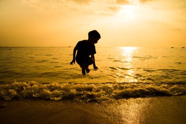 Plaj dalga atlama llittle çocuk silüeti