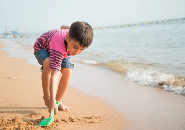 Kleine jongen spelen zand op het strand zomertijd — Stockfoto