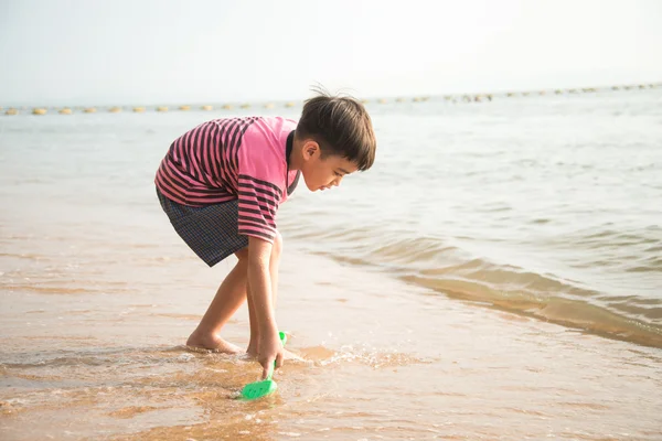 Petit garçon jouant au sable sur la plage heure d "été — Photo