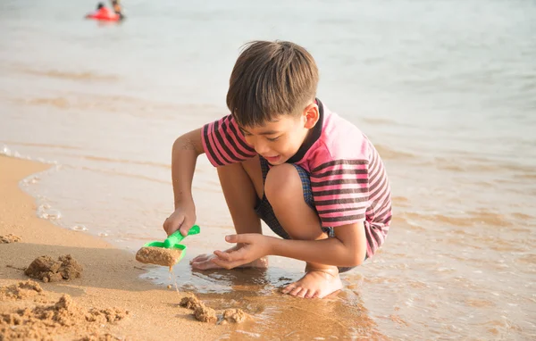 Petit garçon jouant au sable sur la plage heure d "été — Photo