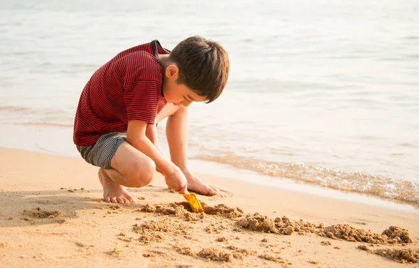 Petit garçon jouant au sable sur la plage heure d "été — Photo