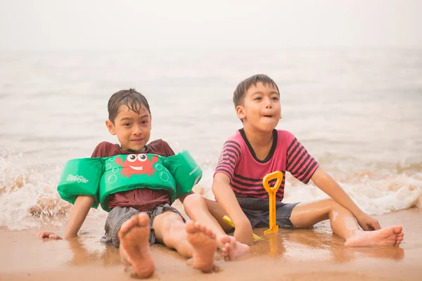 Kleine jongen samen zittend op het strand — Stockfoto