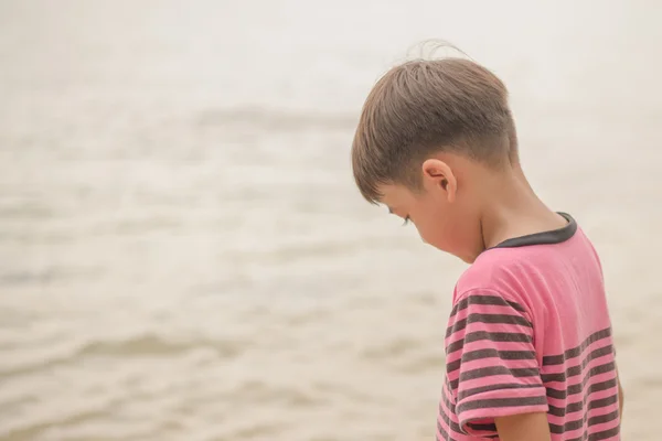 小男孩站在寂寞的海滩上 — 图库照片