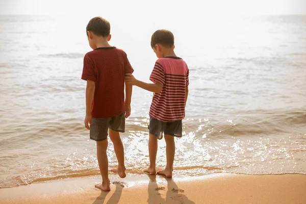 Petit garçon debout ensemble sur la plage — Photo