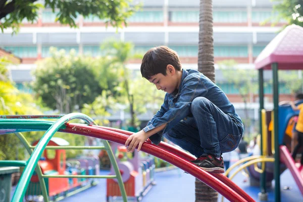 Мальчик забирается на веревку на игровую площадку — стоковое фото