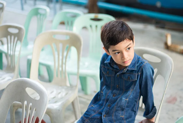 Ragazzino seduto sulla sedia — Foto Stock