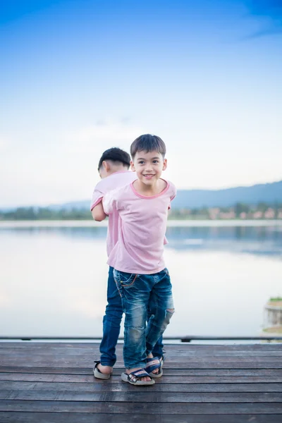 Menino irmão de pé junto próxima lagoa — Fotografia de Stock