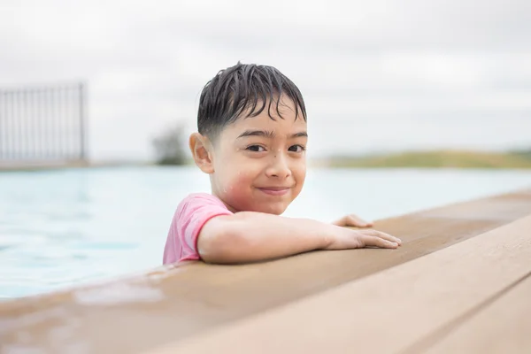 Мальчик играет в воду в бассейне отеля — стоковое фото