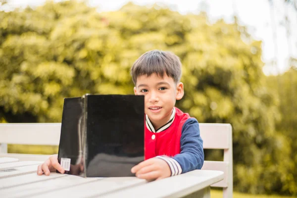 小さな男の子は公園で本を読んで — ストック写真