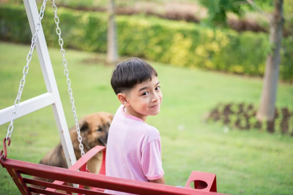 Kleine jongen spelen met hond in het park — Stockfoto