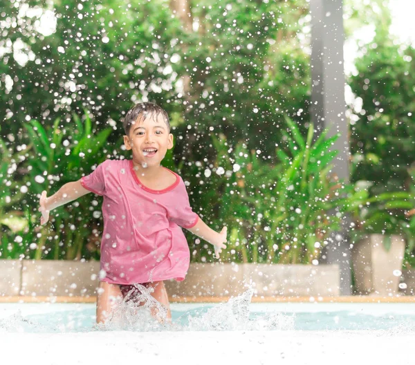 Menino brincando de água na piscina no hotel — Fotografia de Stock