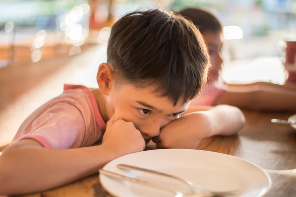 Kleine jongen wachten op eten in de restuarang buiten — Stockfoto