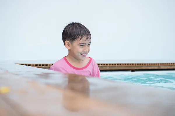 Jongetje speelt water bij zwembad in het hotel — Stockfoto