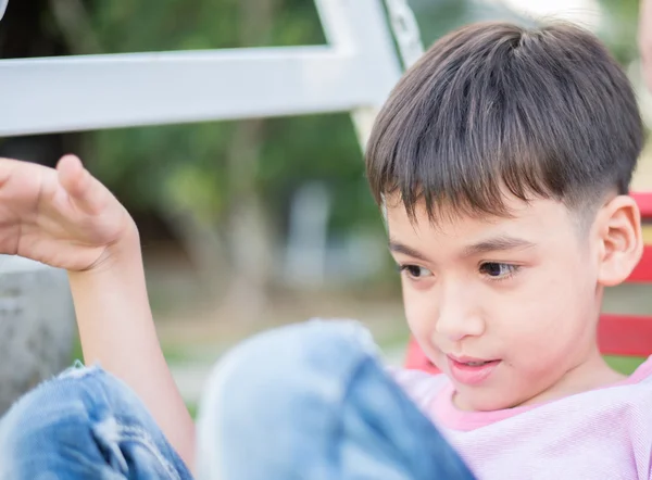 Menino brincando sentado no parque — Fotografia de Stock