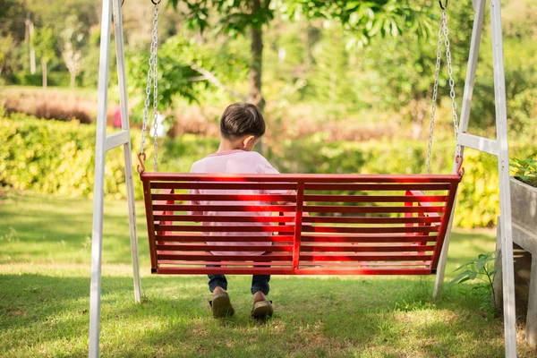 Küçük çocuk oturma parkta sırtını dönme — Stok fotoğraf