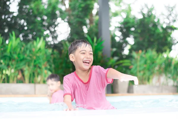 Niño jugando al agua en la piscina del hotel — Foto de Stock