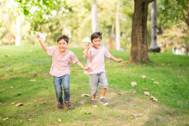 Uçak kağıt parkta oynarken küçük kardeş çocuk