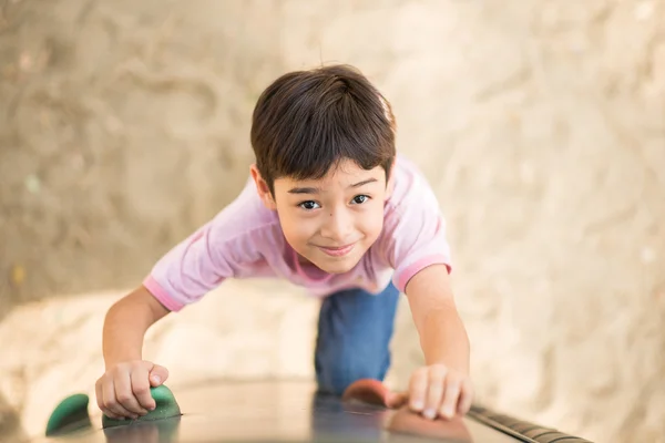 Petit garçon grimpant courageux à l'aire de jeux — Photo