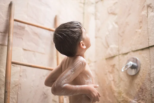 Malý chlapec osprchování v koupelně — Stock fotografie