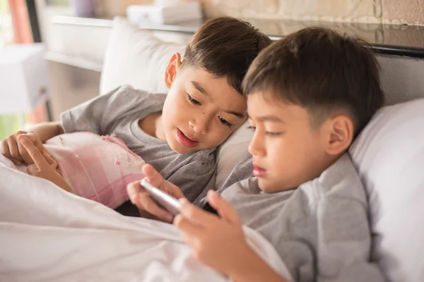 Menino irmão jogando jogo no celular juntos — Fotografia de Stock