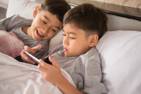 Menino irmão jogando jogo no celular juntos — Fotografia de Stock