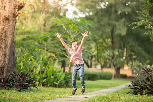 Liten pojke hoppar höjd i parken — Stockfoto