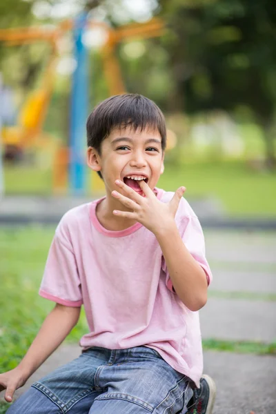 Menino sorrindo no parque no verão — Fotografia de Stock