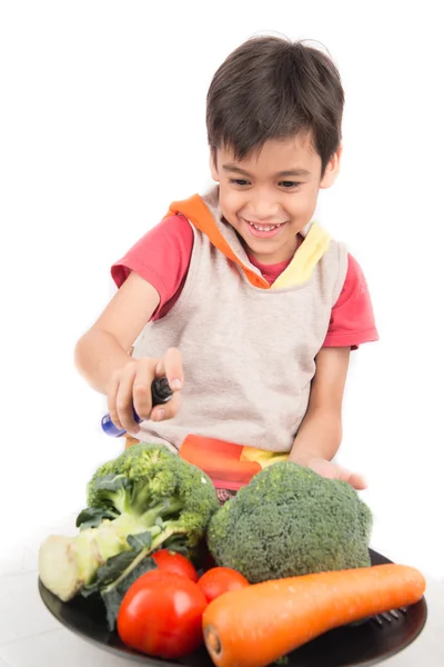 Kleiner Junge isst Gemüse auf Gericht auf weißem Hintergrund — Stockfoto