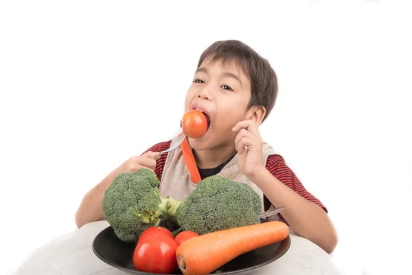 Kleiner Junge isst Gemüse auf Gericht auf weißem Hintergrund — Stockfoto