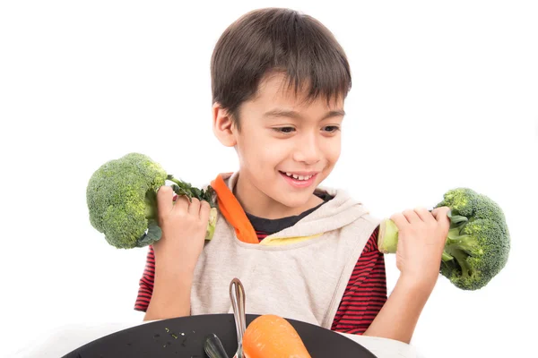 Kleiner Junge isst Gemüse auf Gericht auf weißem Hintergrund — Stockfoto