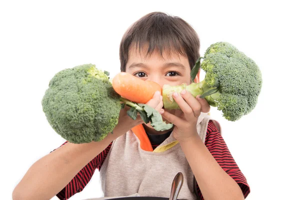 Мальчик ест овощи на белом фоне — стоковое фото