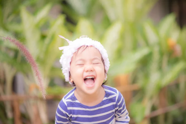 Petite fille asiatique mignonne touchant herbe de fleur — Photo