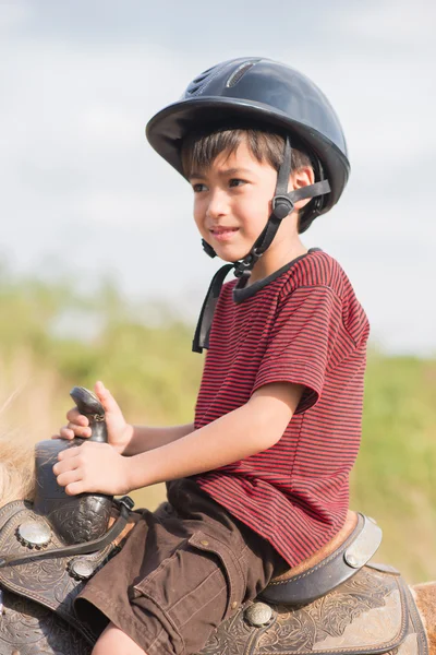 Little boy riding training horse — Stock Photo, Image