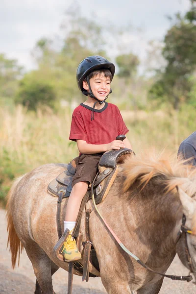 Little boy ridning utbildning häst — Stockfoto