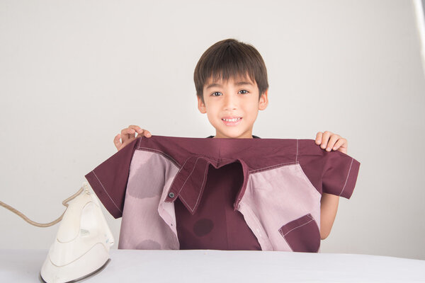 Мальчик гладит домашнюю работу
