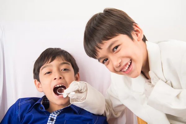 同级的小男孩假装作为一个牙医 vlittle 同级男孩假装成附近的牙医了内口检查 — 图库照片
