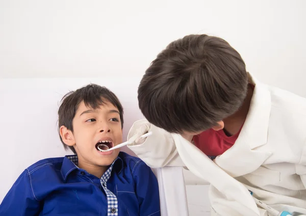 Menino irmão fingir como um dentista vMenino irmão fingir como um dentista close up dentro da boca check-up — Fotografia de Stock